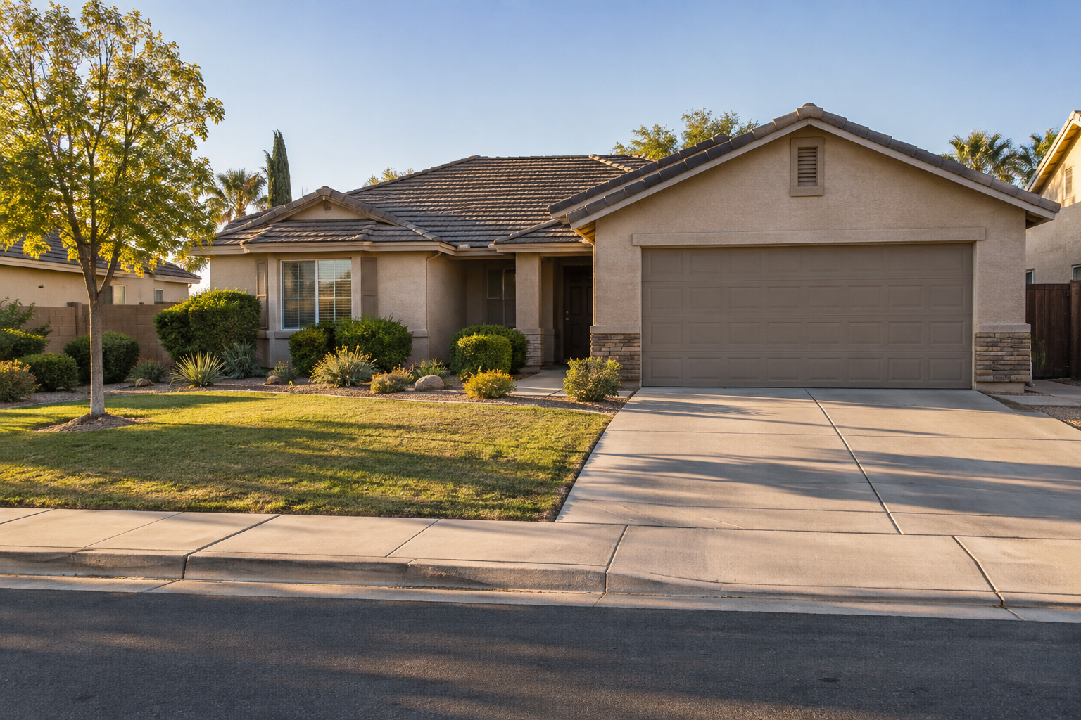 Single-story stucco home in Bakersfield, California, with a shaded entry and drought-tolerant front yard.